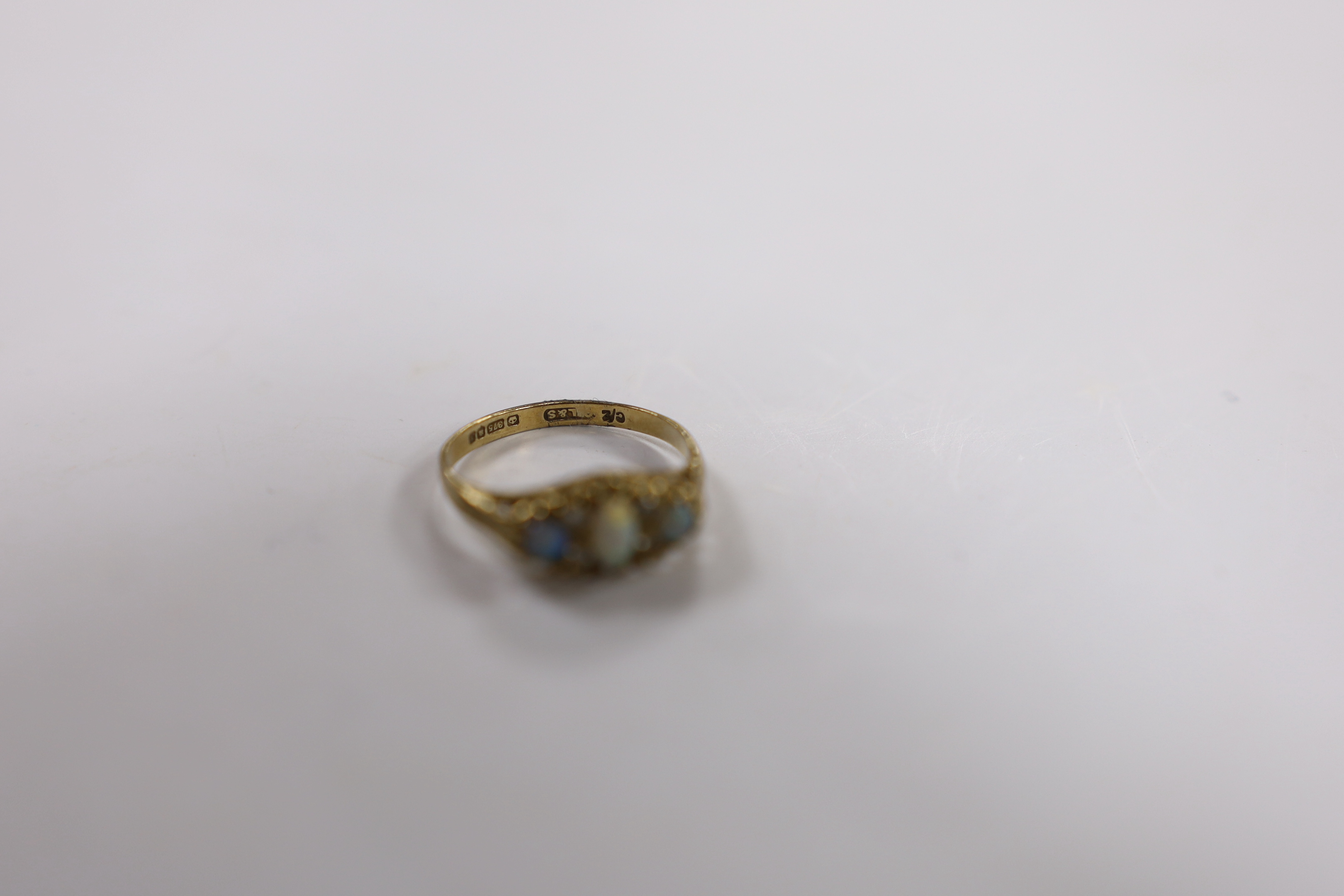 A 9ct gold and three stone white opal set ring, with CZ spacers, size L, gross weight 1.6 grams.